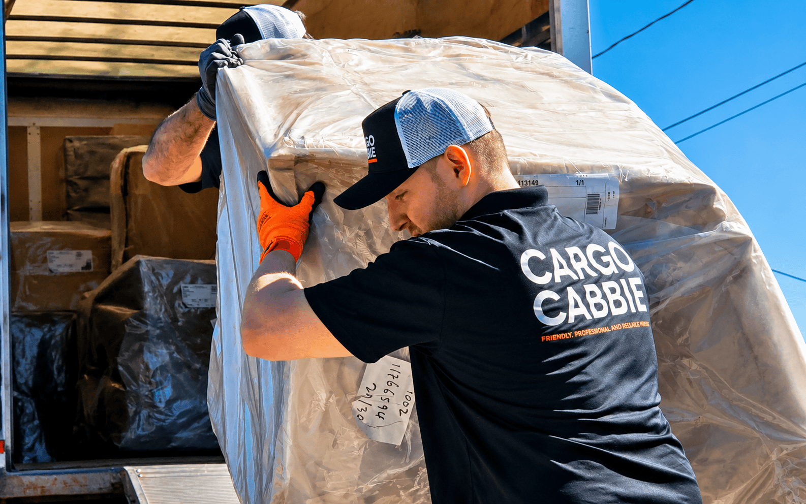 CARGO CABBIE movers loading a wrapped furniture piece onto the truck for an express delivery in Toronto
